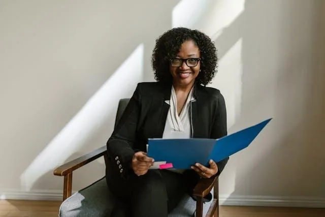 Person sitting in a chair and holding a folder